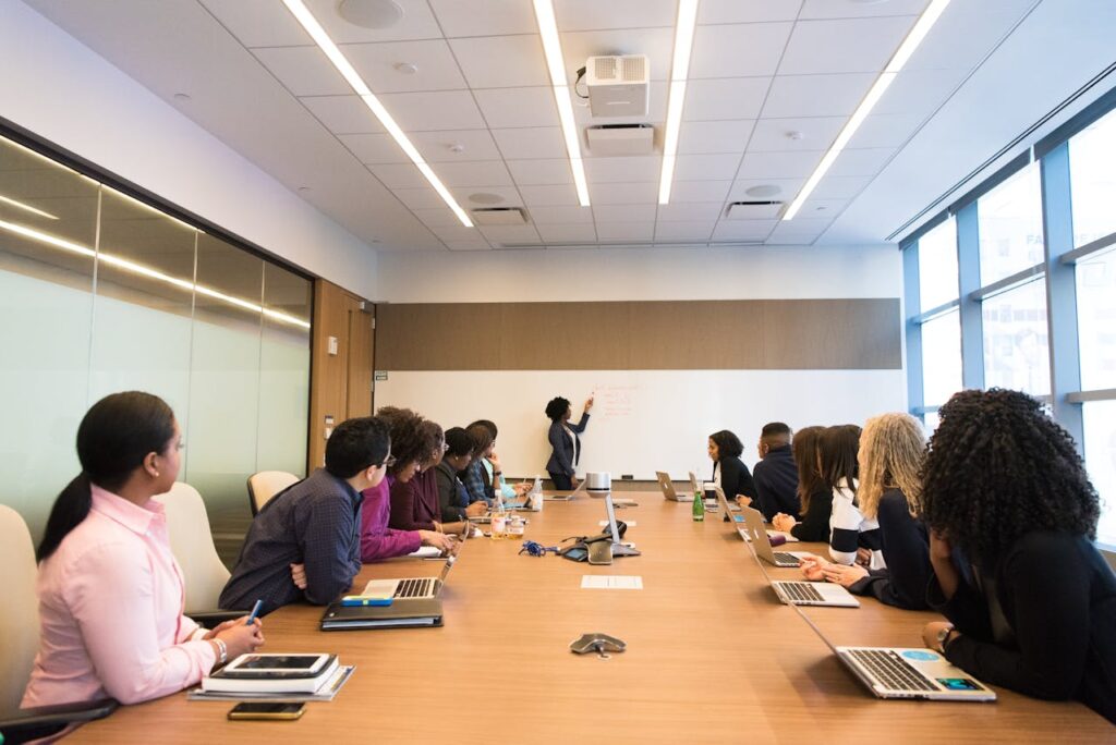 A group of employees sitting at a table watching a presentation.