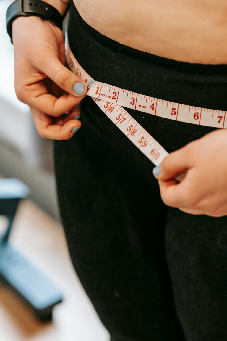 A woman holding a tape measure around her hips
