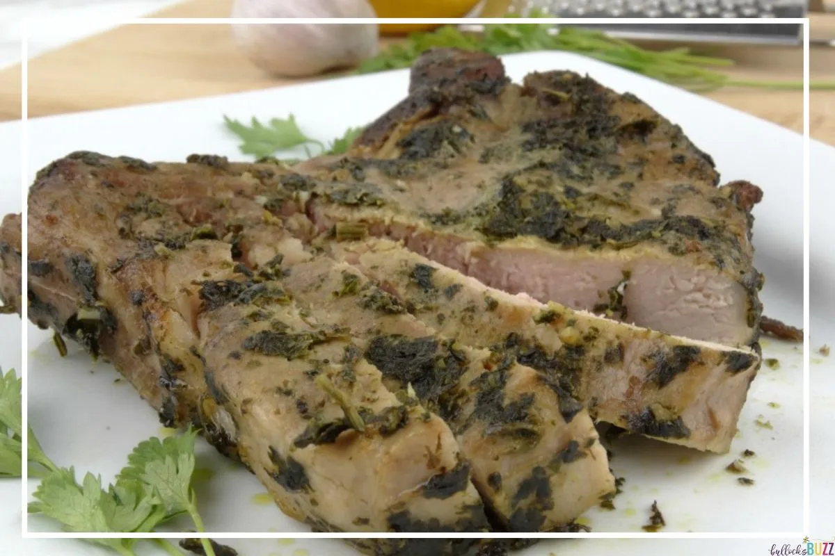Sous Vide Garlic Basil Rubbed Pork Chops on a white plate. This is one of the most popular low-carb dinners on the Bullocks Buzz blog.