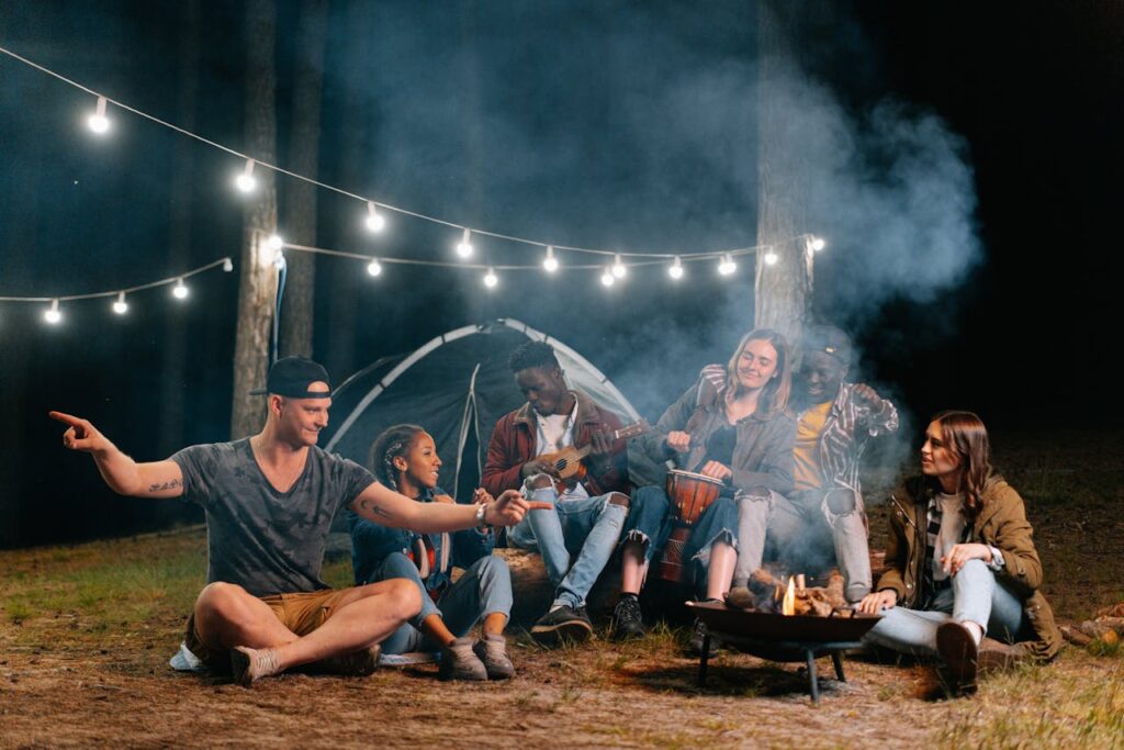Friends enjoying a campfire at night on a camping trip, showing how well-organized trips create fun and stress-free moments together.
