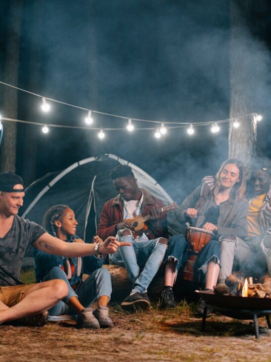Friends enjoying a campfire at night on a camping trip, showing how well-organized trips create fun and stress-free moments together.