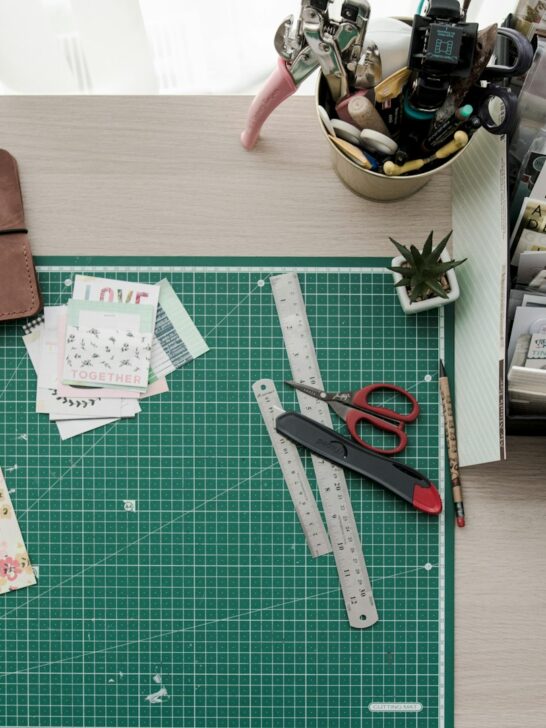 Craft room organization tips with crafting tools neatly arranged on a tabletop, including scissors, paintbrushes, markers, and measuring tape.