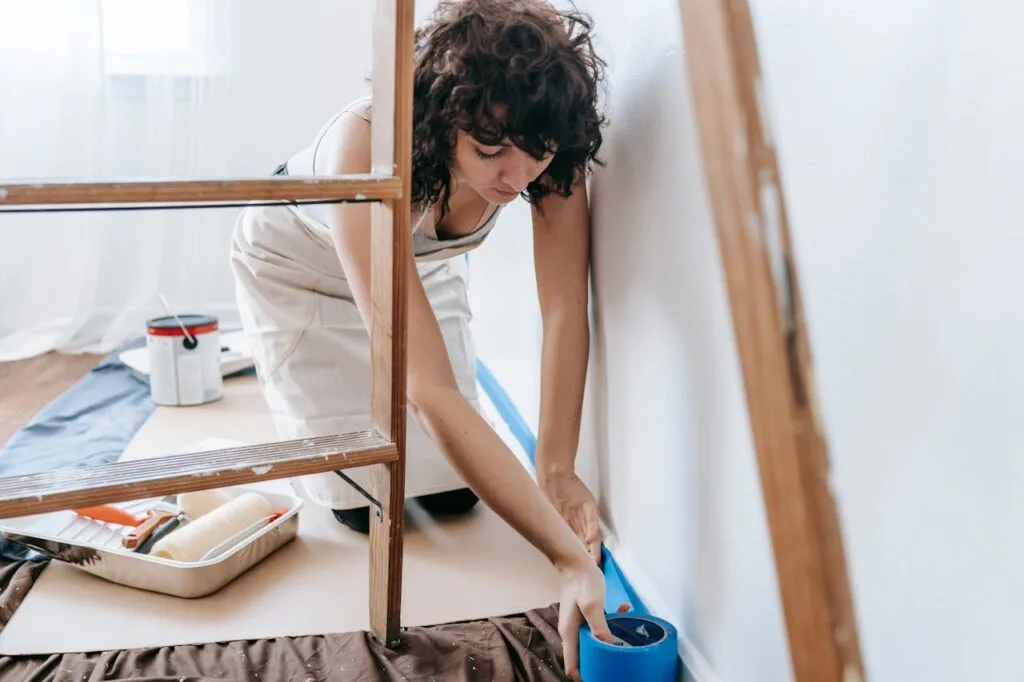a woman getting ready to paint as one of the easy DIY touch-ups that help your home sell fast