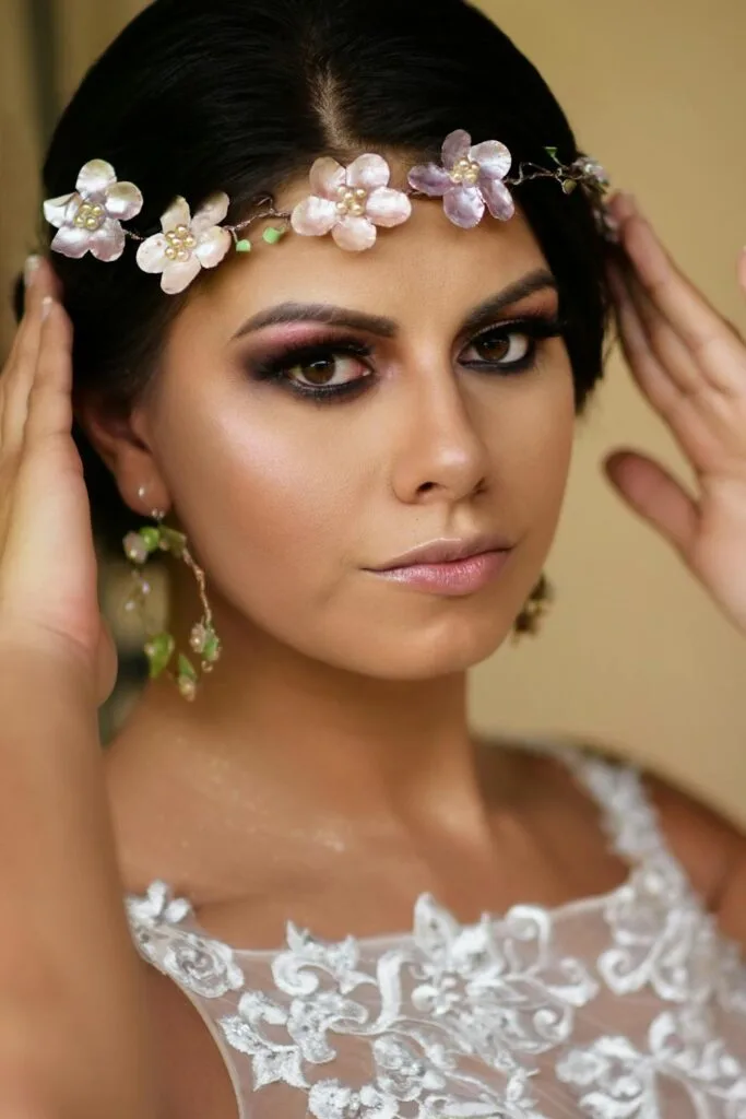 Bride with glowing skin on your wedding day wearing floral headpiece and lace gown, showing a radiant bridal look.