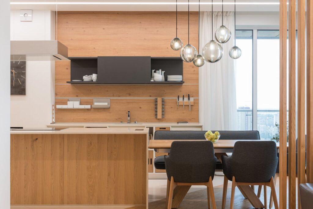 Modern kitchen and dining area with pendant lights, showcasing practical lighting design tips for a bright and stylish home.