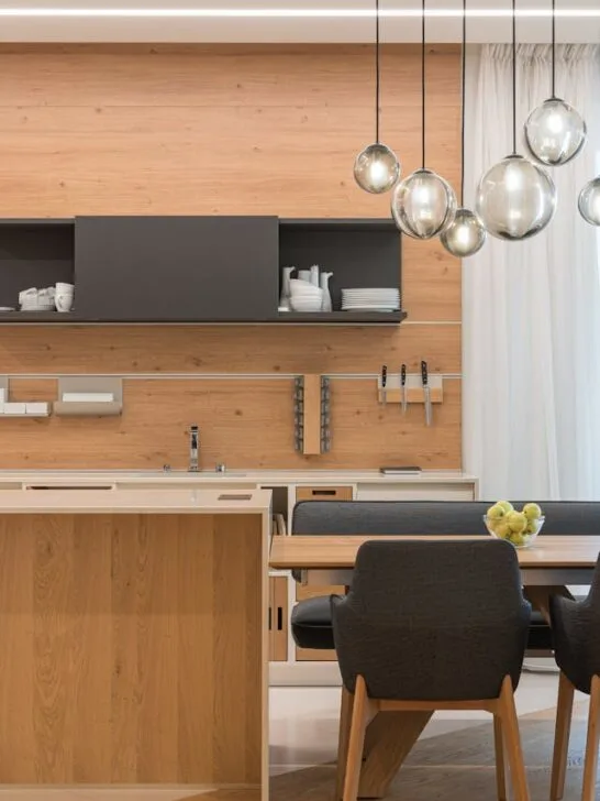 Modern kitchen and dining area with pendant lights, showcasing practical lighting design tips for a bright and stylish home.