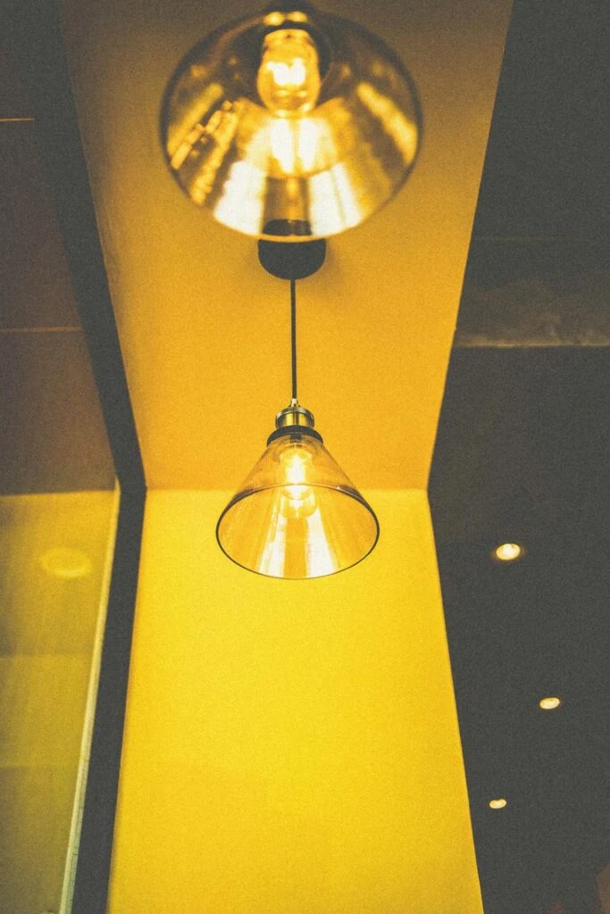 Two pendant ceiling lights glowing warmly, an example of stylish lighting design tips.