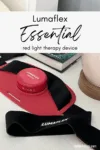 Lumaflex Essential red light therapy device with straps, shown on a desk beside a book and lamp