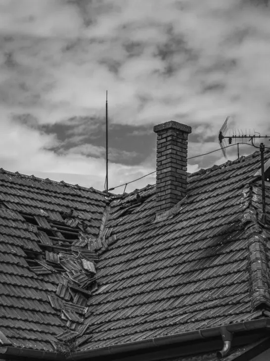 Damaged roof with broken and missing shingles — a clear example of the signs it’s time to repair your roof