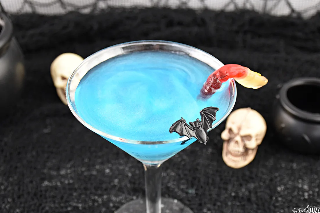 close up of spider and gummy worm garnishes on the Halloween Cocktail