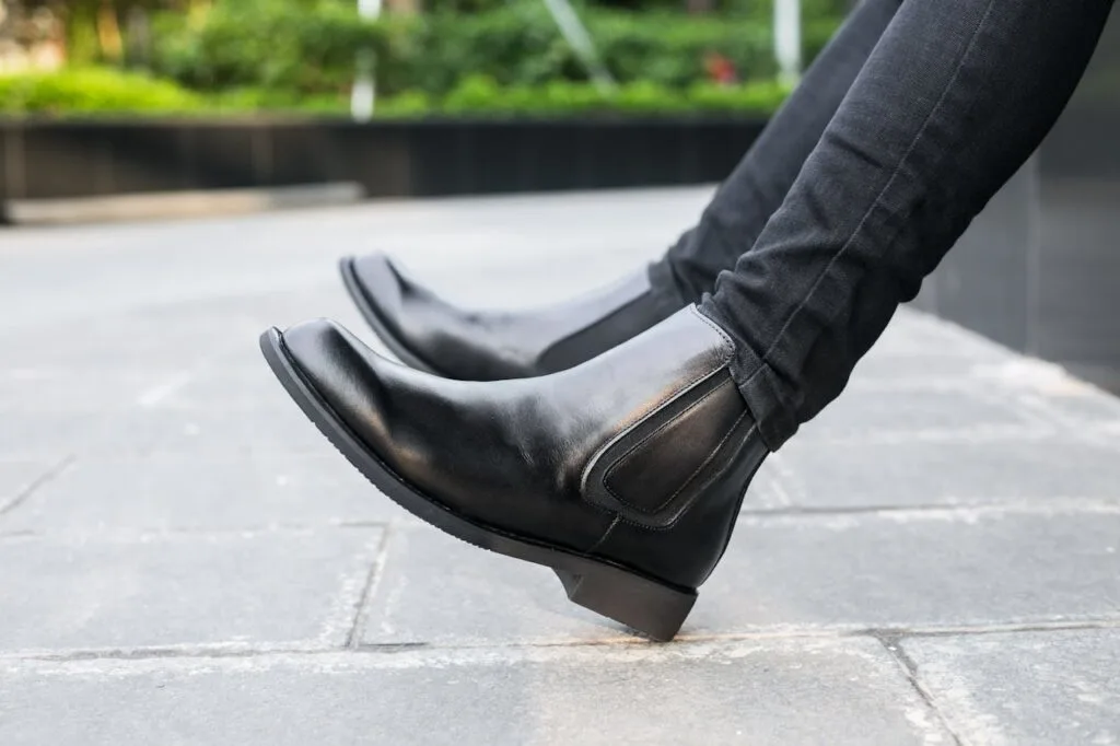 A woman wearing timeless women&rsquo;s boots styled as chic ankle boots while sitting down outside