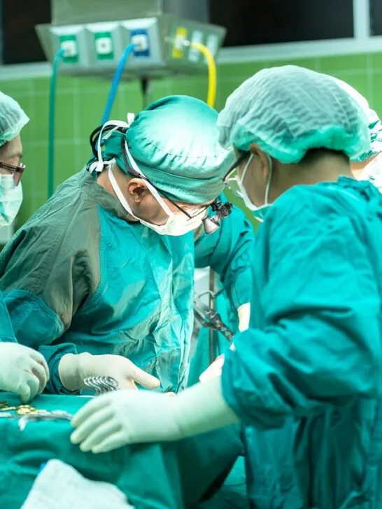 Medical team performing surgery in an operating room, representing why people choose plastic surgery for health and appearance.