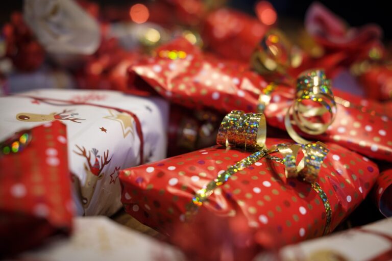 Brightly wrapped holiday presents in red and white paper with gold ribbons, perfect inspiration for creative personalized gift ideas.