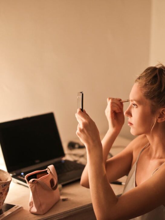 Woman using a small makeup pouch at her vanity, showing how the best makeup bag keeps beauty essentials organized for easy everyday routines