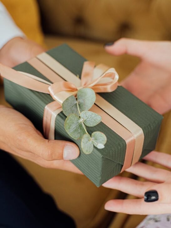 A person handing a gift to another representing personalized gift ideas