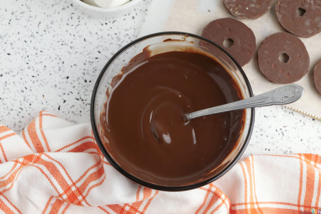 A clear glass bowl with melted chocolate that is smooth and shiny, ready for dipping