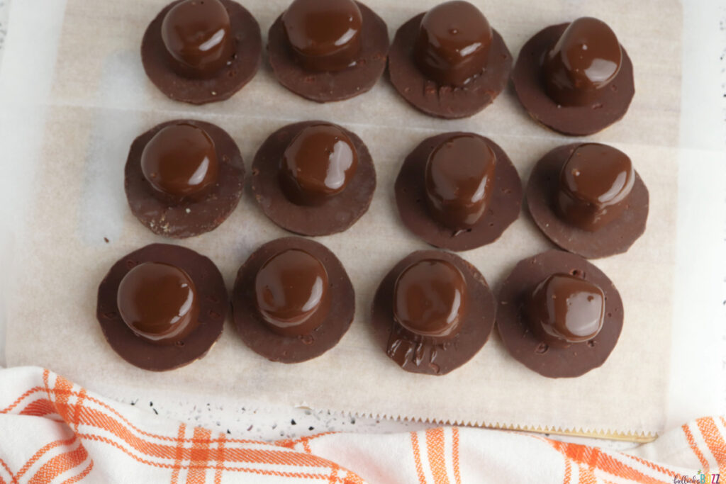 Tray of chocolate-covered marshmallow Pilgrim hats chilling on parchment paper