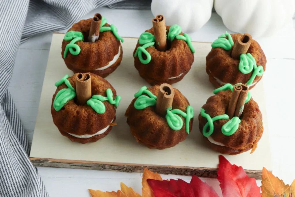 pumpkin cakes assembled and decorated on a cutting board, ready to eat