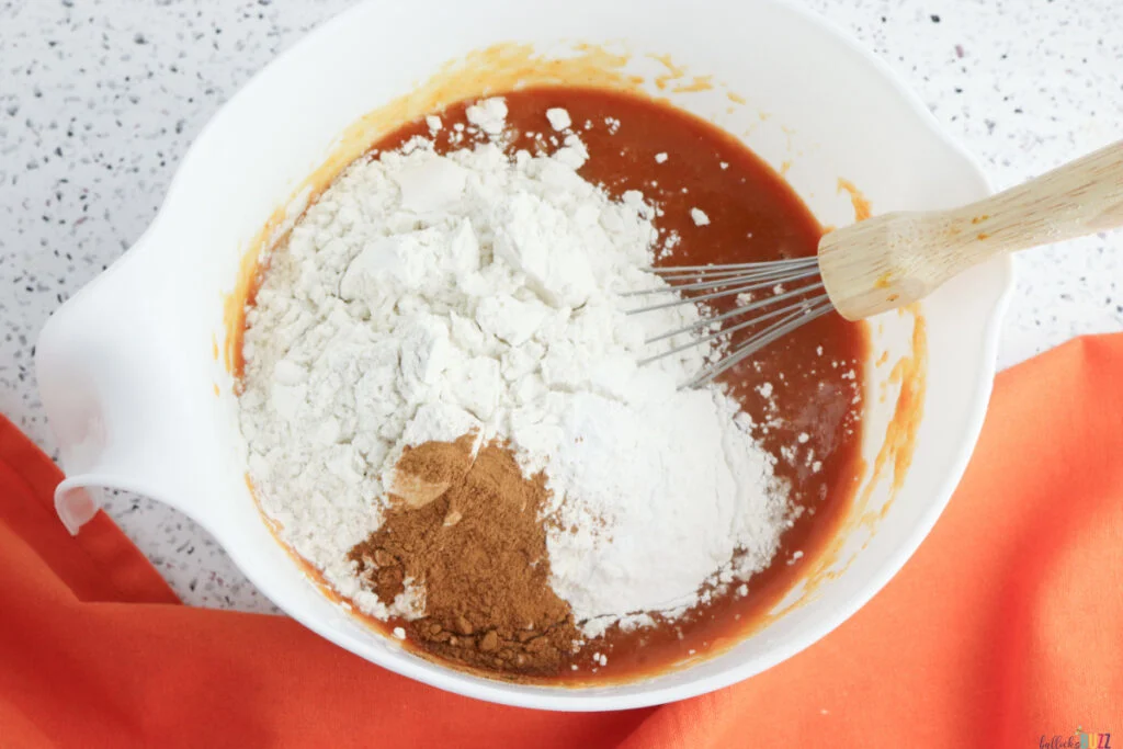 Adding flour and pumpkin spice to wet mixture for pumpkin cakes batter