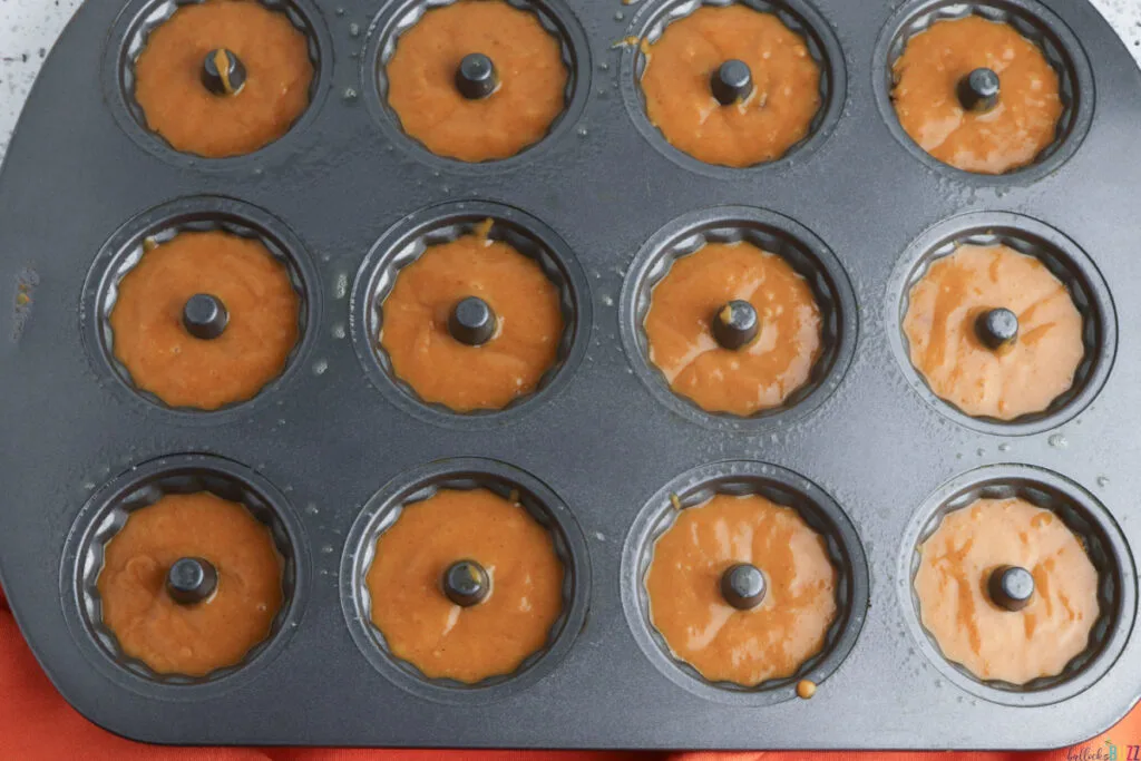 Batter spooned into mini Bundt pans ready to bake
