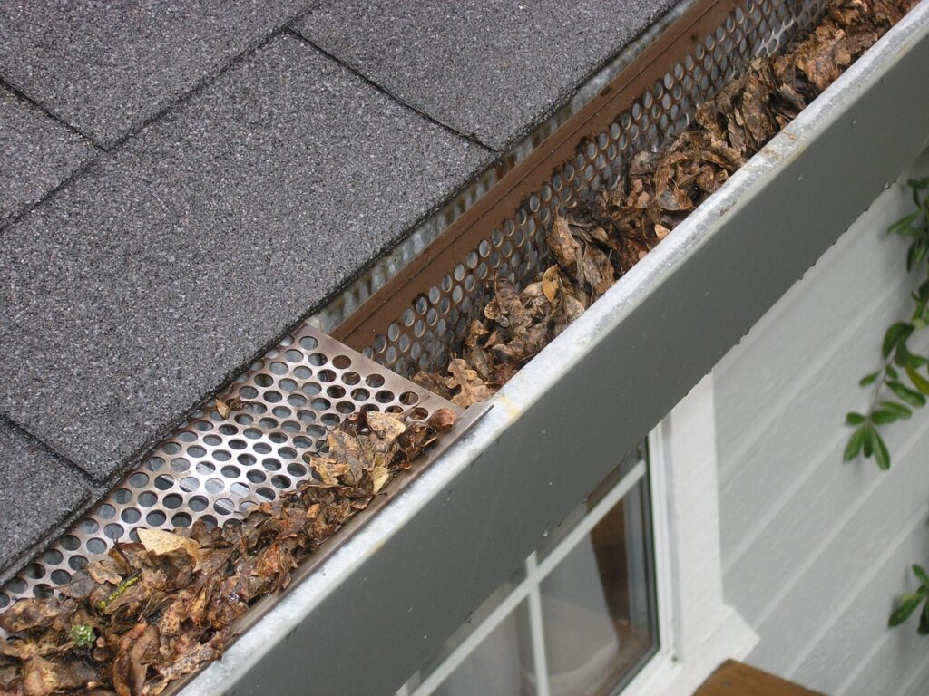 Clogged gutter filled with leaves showing poor roof maintenance and the need for regular cleaning to prevent water damage
