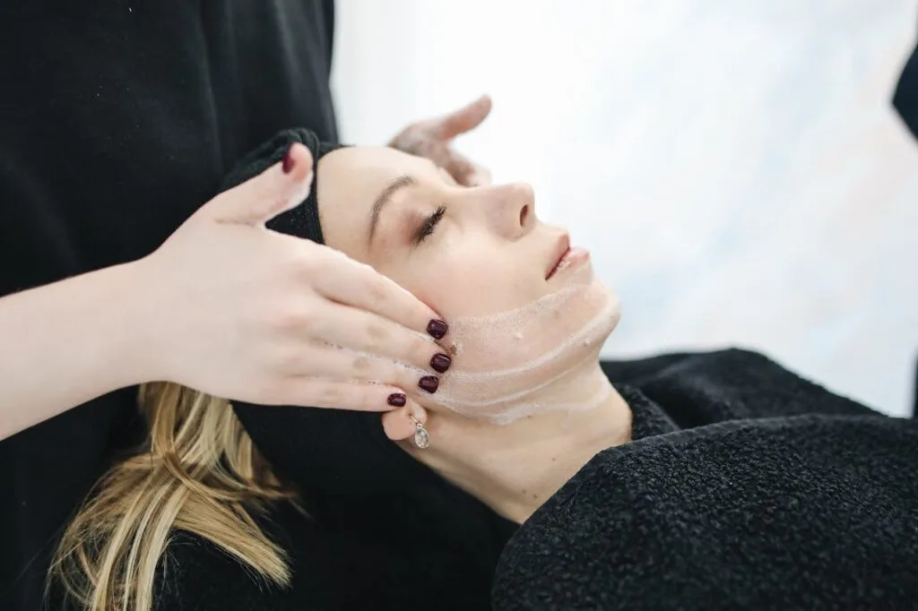 A woman enjoying a relaxing facial treatment at a spa, showcasing the benefits of skin wellness and self-care.