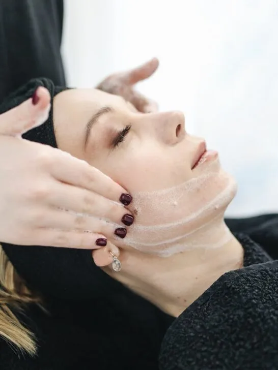 A woman enjoying a relaxing facial treatment at a spa, showcasing the benefits of skin wellness and self-care.
