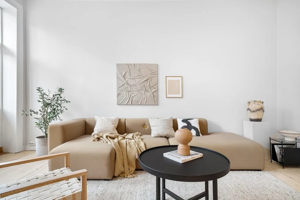 Minimalist living space with soft lighting, cozy beige furniture, and subtle decor that creates a warm, relaxing atmosphere.
