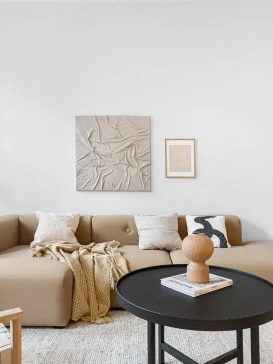 Minimalist living space with soft lighting, cozy beige furniture, and subtle decor that creates a warm, relaxing atmosphere.