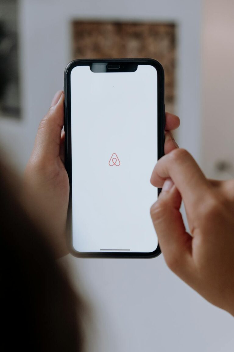 Opening the Airbnb app on a smartphone, a common first step when researching Airbnb hosting tips and listing a propert