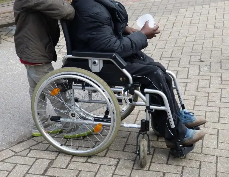 A person in a wheelchair being assisted outdoors, capturing daily support, inclusion, and NDIS participant wellbeing.