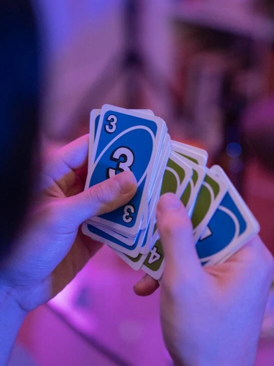 Games night ideas with friends playing a card game together in a relaxed, colorful setting
