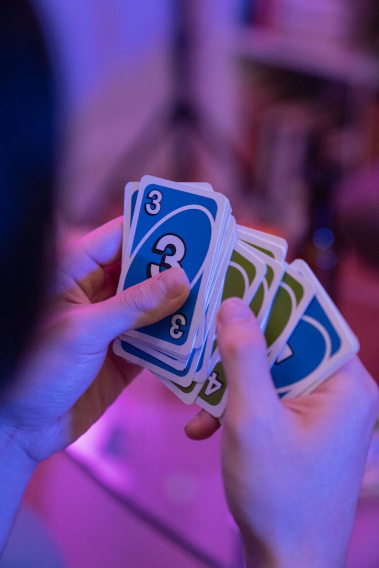 Games night ideas with friends playing a card game together in a relaxed, colorful setting