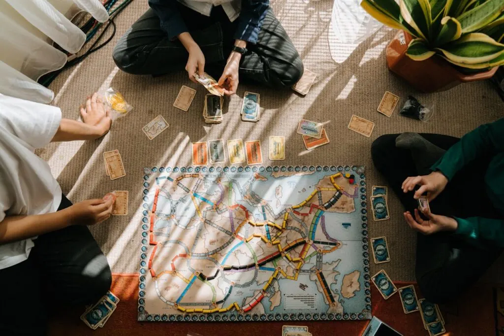 Friends sitting on the floor playing a board game together during a cosy game night at home