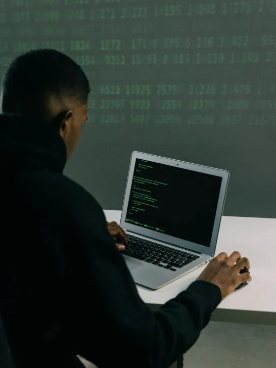 Man working on a laptop with code on the screen, highlighting the need for strong online privacy tools.