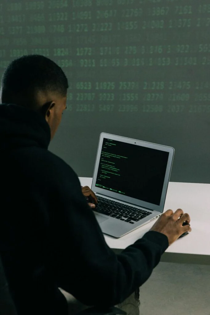 Man working on a laptop with code on the screen, highlighting the need for strong online privacy tools.