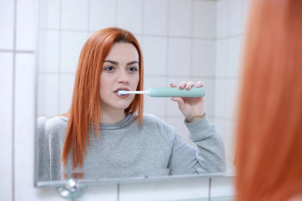 Adult brushing teeth at home as part of a daily routine that supports oral health across different life stages