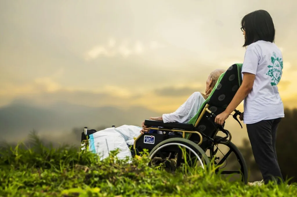 Hospice care for advanced liver disease patient resting in a wheelchair while receiving support outdoors
