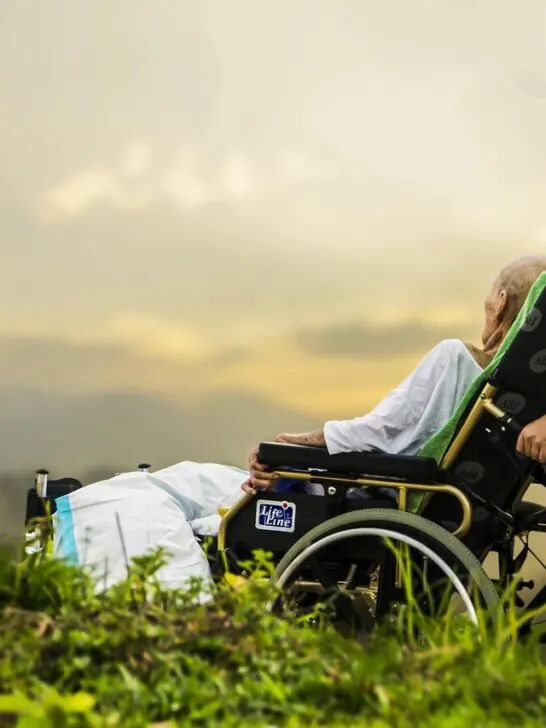 Hospice care for advanced liver disease patient resting in a wheelchair while receiving support outdoors