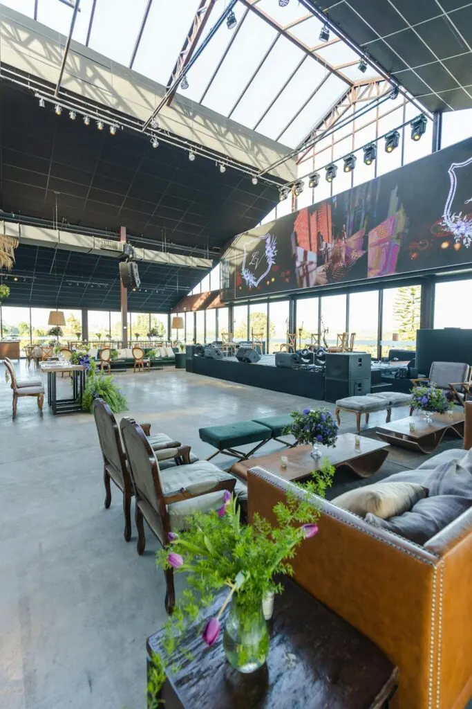 Modern indoor event venue with comfortable seating, stage lighting, and an open layout designed for an elegant celebration.