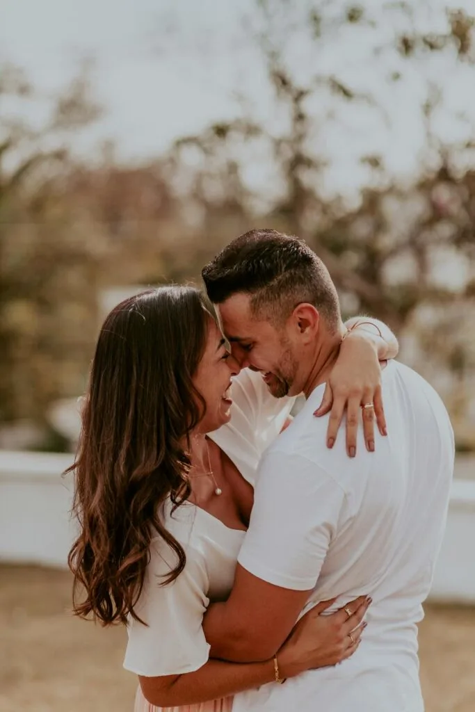 Couple embracing outdoors, smiling and supporting one another while navigating the causes and effects of infertility together.