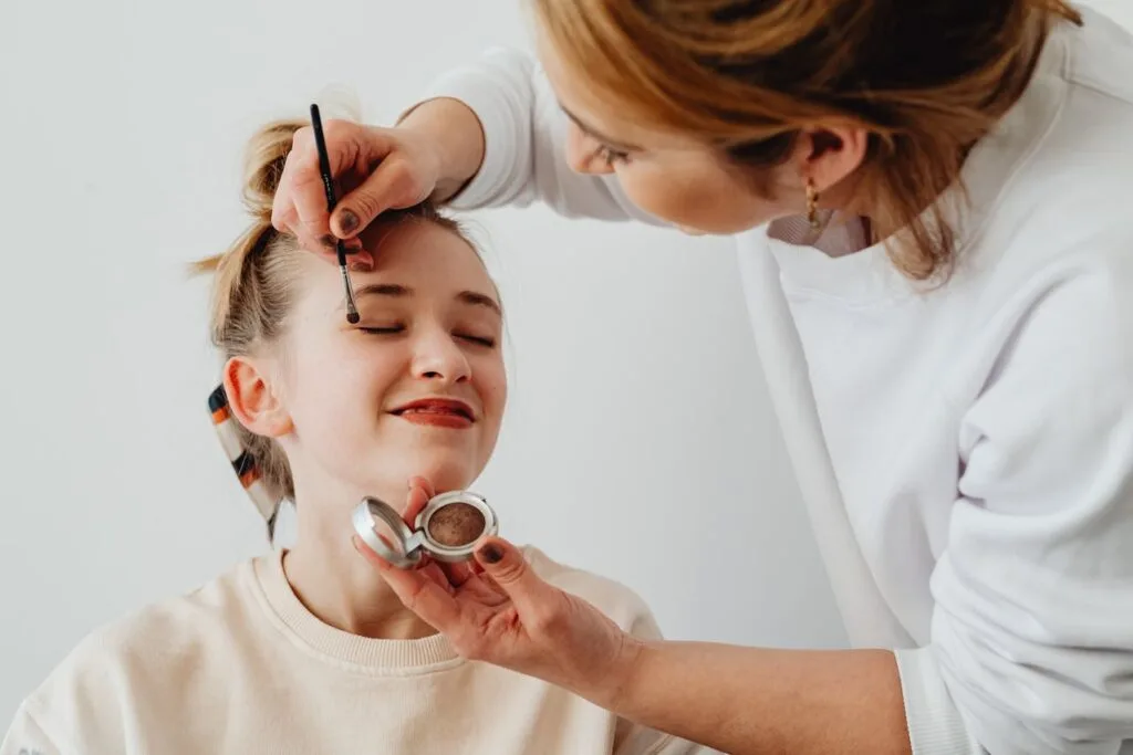 Beauty professional applying eye makeup using high-quality beauty salon products to ensure safe, precise, and professional results for the client.
