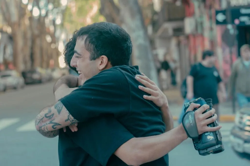 Two men hugging on a city street, symbolizing life-changing recovery progress and emotional support during addiction recovery.
