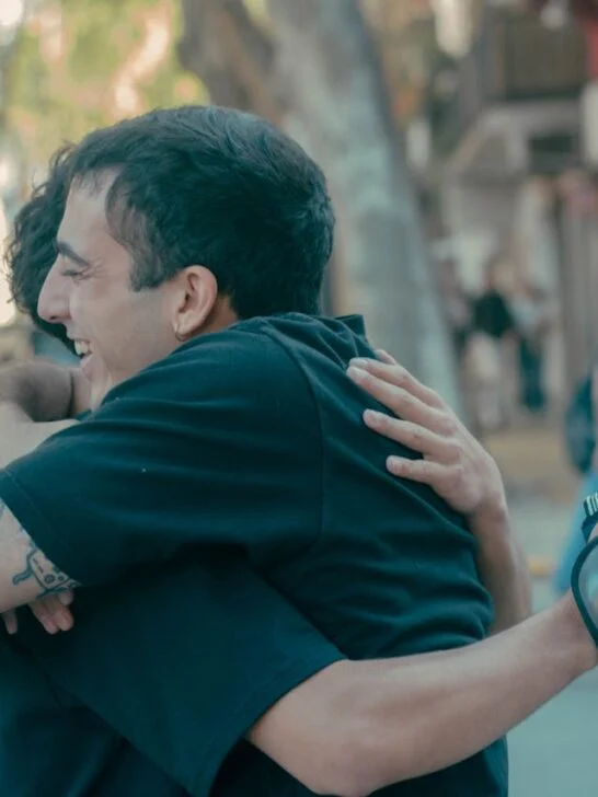 Two men hugging on a city street, symbolizing life-changing recovery progress and emotional support during addiction recovery.