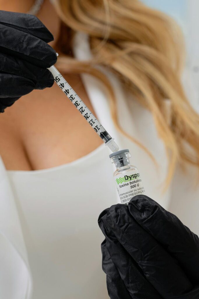 Medical professional preparing a syringe with botulinum toxin for a cosmetic treatment.