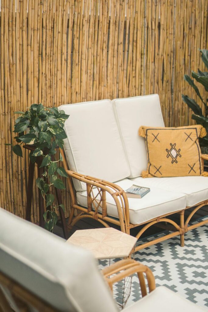 sustainable outdoor seating area with bamboo wall, cushioned bench, and potted plants