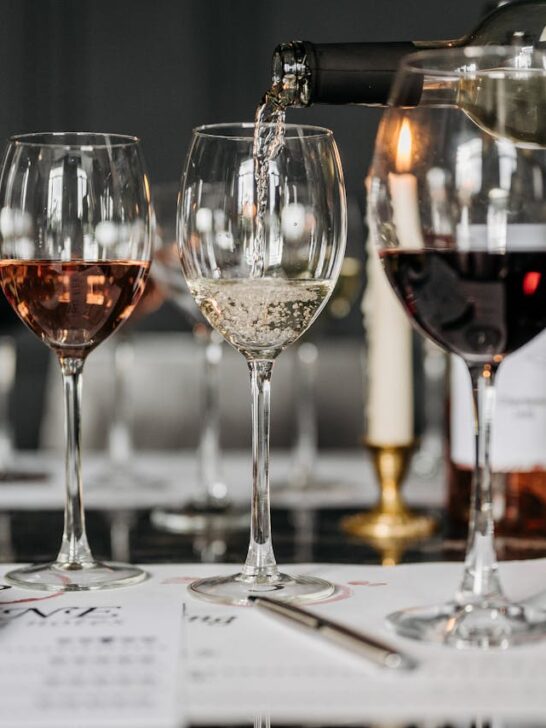 Multiple glasses of red, white, and ros&eacute; wine lined up during a wine tasting, illustrating how to taste wine and compare different flavors