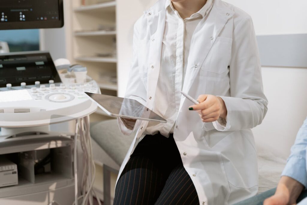 Doctor reviewing patient information on a tablet during a checkup, highlighting the importance of routine medical screenings
