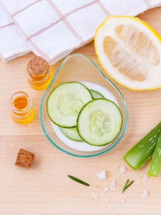 how natural ingredients support skin health with cucumber slices, aloe vera, lemon, and nourishing oils on a wooden surface