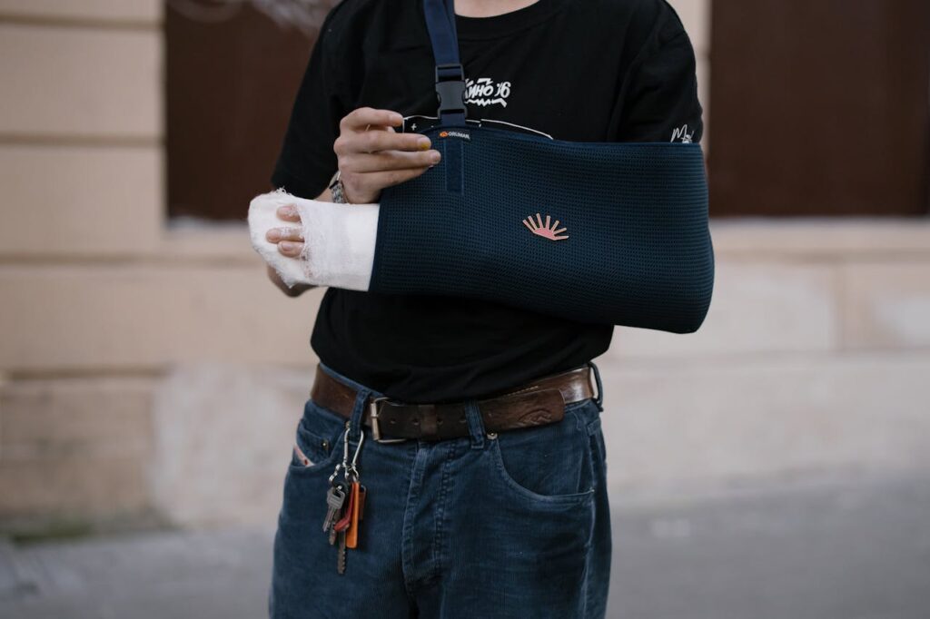 Person wearing an arm sling and wrist cast after an injury at a public event.